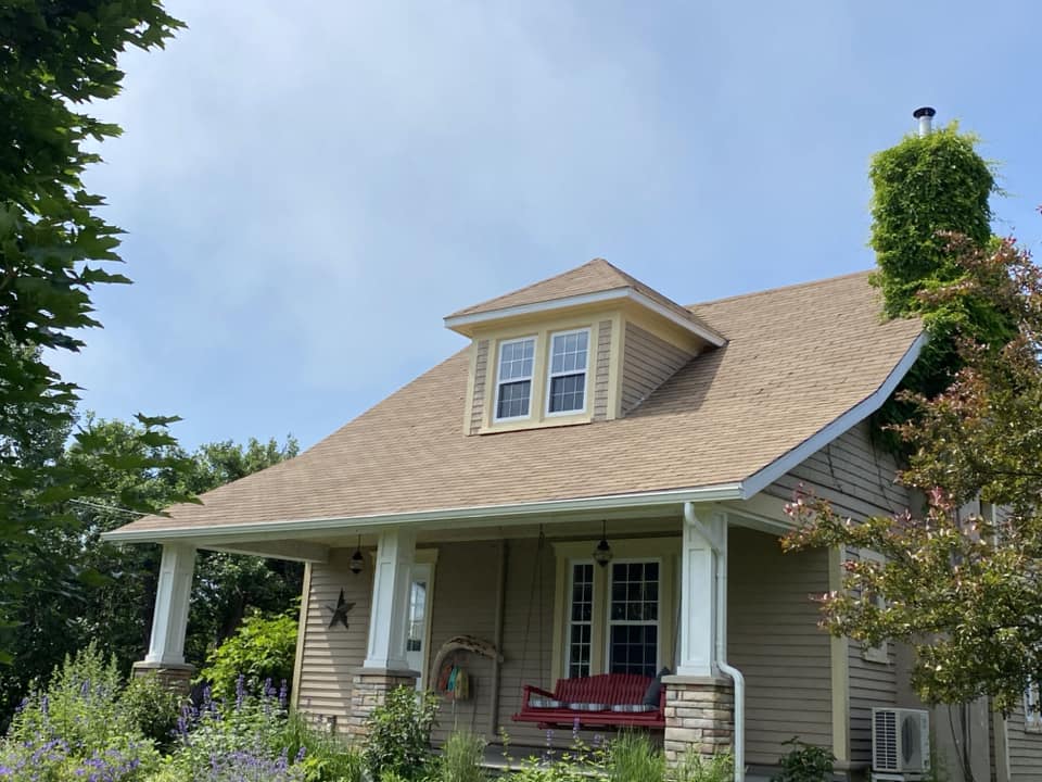 Craftsman-style home with rejuvenated roof, porch swing, and landscaped yard